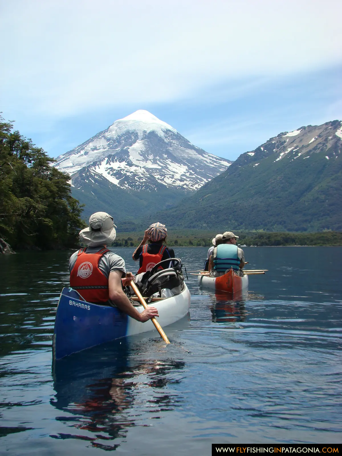 Canoeing on a mountain lake beneath Lanin Volcano